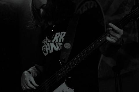 Show da ultra 77 no Armazém 77 lu tocando seu baixo, foto em preto e branco'