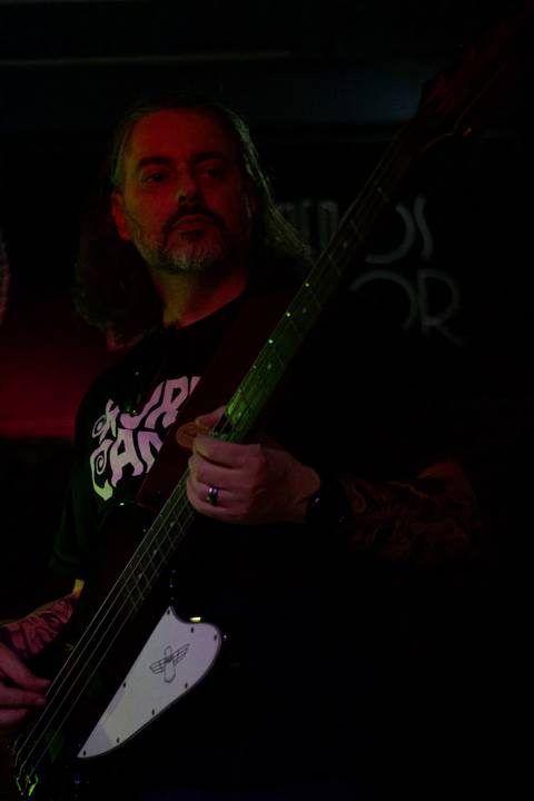 Show da ultra 77 no Armazém 77 luciano olhando diretamente para seu instrumento, baixo, foto colorida'