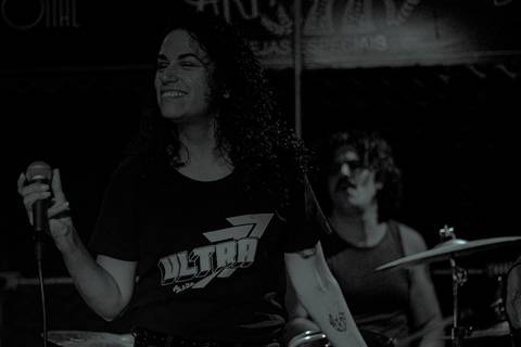 Show da ultra 77 no Armazém 77 renata cantando, enquando dança sorrindo'