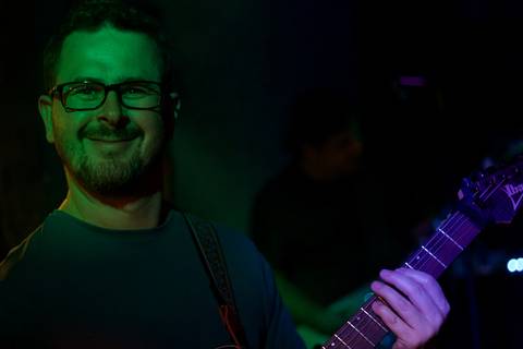 Show da ultra 77 no Armazém 77 rafael olhando diretamente para a câmera enquanto toca seu instrumento'