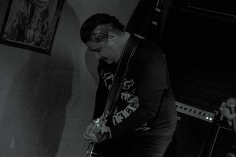 Show da ultra 77 no Armazém 77 markus encurvado enquanto toca seu instrumento'