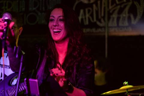 Show da ultra 77 no Armazém 77 juliana colocando o microfone no seu devido lugar, enquanto sorri'