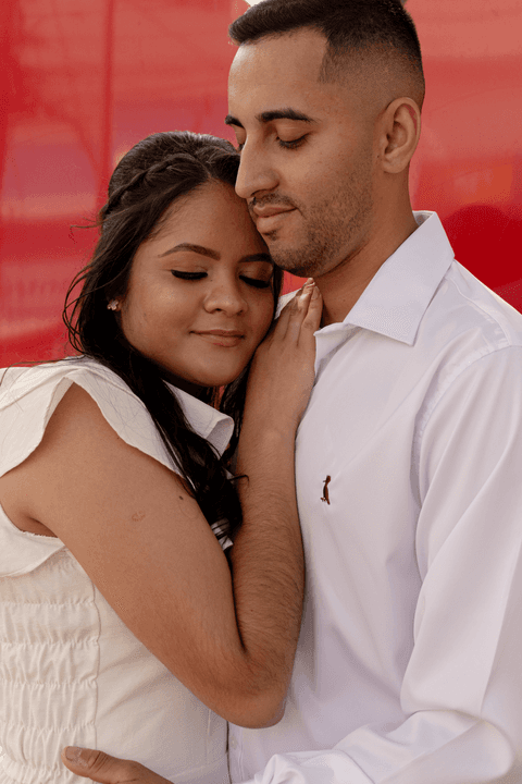 casamento no civil bárbara e guilherme juntos, na praça em frente ao cartório, bárbara abraçada com guilherme, encostando a cabeça em seu peito'