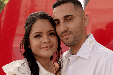 casamento no civil bárbara e guilherme juntos, na praça em frente ao cartório, ambos de frente para mim, de fundo o coração vermelho'