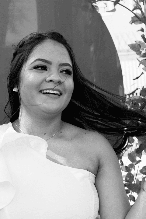 casamento no civil bárbara e guilherme juntos, na praça em frente ao cartório, bárbara com cabelos ao vento, em frente ao coração vermelho, foto em preto e branco'