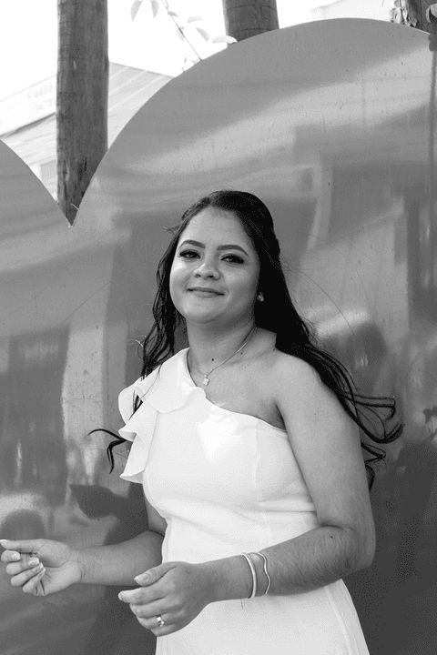 casamento no civil bárbara e guilherme juntos, na praça em frente ao cartório, bárbara em leve balanço em frente ao coração vermelho, foto em preto e branco'