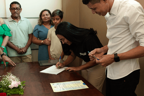 casamento no civil a outra funcionária do cartório assinando as papeladas do casamento, dentro da sala do cartório'