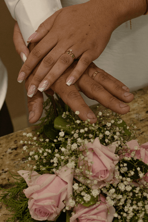 casamento no civil mãos de guilherme e bárbara mostrando as alianças ao lado do buquê'