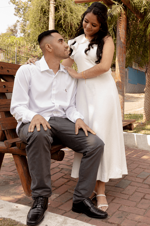 casamento no civil bárbara e guilherme juntos, na praça em frente ao cartório, trocando olhares apaixonados, guilherme sentado no banco '