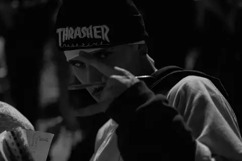 batalha do celeste organizador da batalha olhando diretamente para a câmera, com sua caneta em mãos'