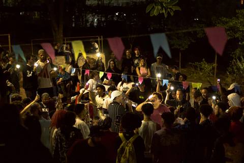 batalha do celeste em ângulo mais distante, temos uma visualização inteira da batalha, época de festa junina com as bandeirinhas penduradas e o pessoal com a lanterna dos celulares ligados'