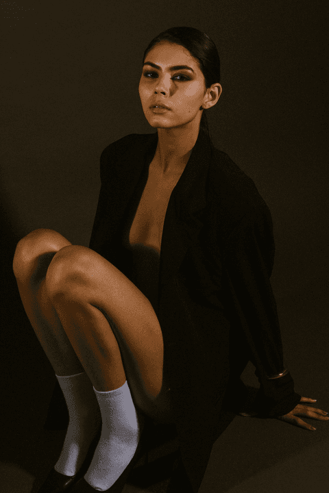 bia sentada no estúdio com as mãos apoiando seu corpo'