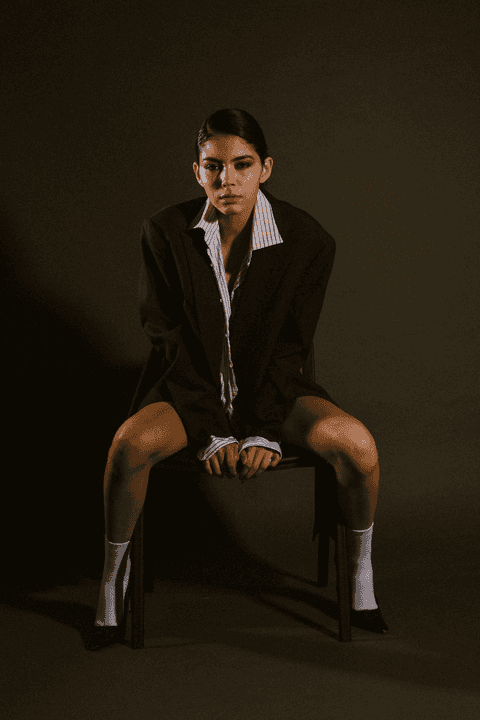 bia com as pernas abertas sentada na cadeira'
