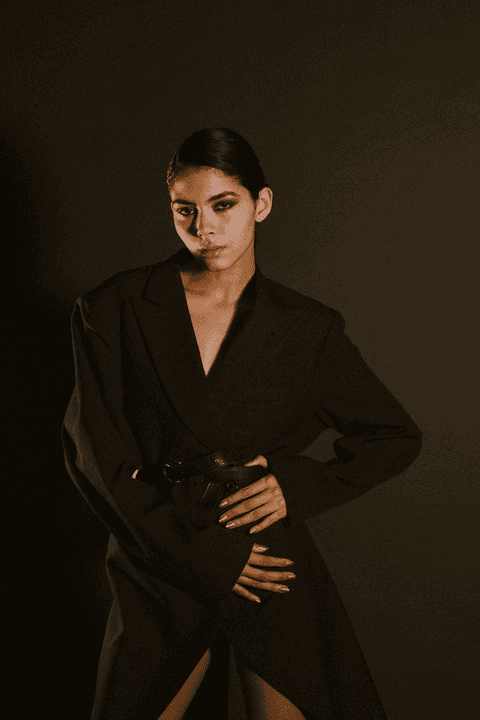 bia com um novo look, com cinto enquanto coloca a mão em sua cintura'