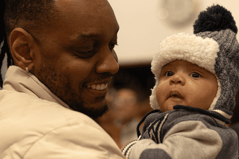 bryan com seu pai no colo, dentro da igreja, após apresentação'