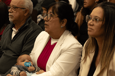 a família de bryan na igreja atento a fala dos pastores, aguardando o momento da apresentação'