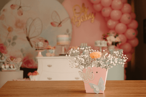 chá de bebê da maya vasinho de plantas em primeiro plano, decoração completa da maya ao fundo'