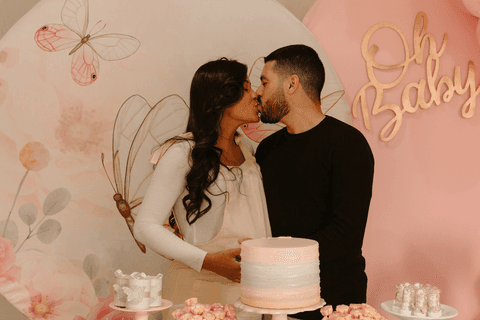 chá de bebê da maya pais de maya se beijam em frente a decoração de borboletas'