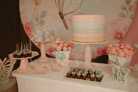 chá de bebê da maya decoração do bolo na mesa principal e dos docinhos, fundo de borboleta'