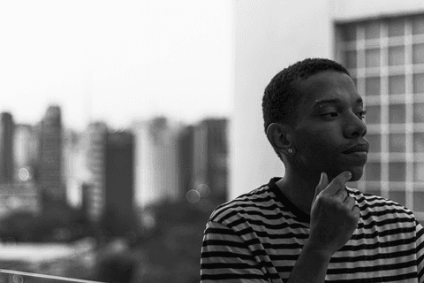 jerf no terraço do mac fundo de quadradinhos de vidro e a outra metade com os prédios da cidade ao fundo'