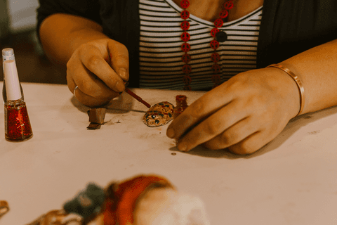 sesc paulista oficina de criação de jóais, aluna pintando sua jóia com esmalte, enquadramento mais próximo'