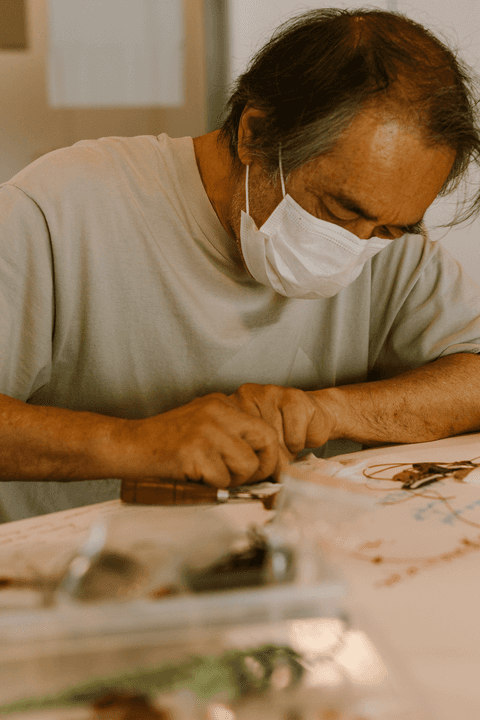 sesc paulista oficina de criação de jóais, aluno focado montando sua obra artística'