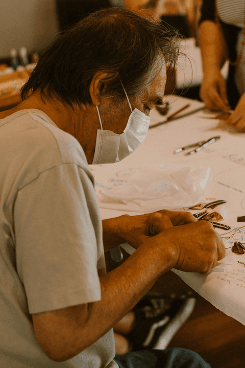 sesc paulista oficina de criação de jóais, aluno agora de costas para a câmera enquanto continua trabalhando'