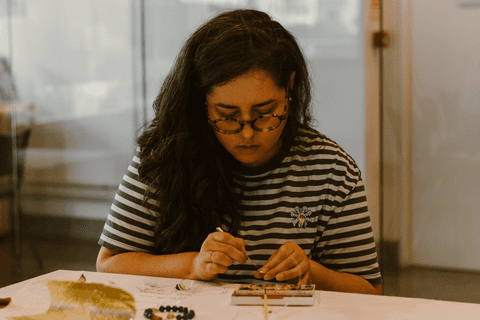 sesc paulista oficina de criação de jóais, aluna concentrada, usando tintas para a criação de suas jóias'