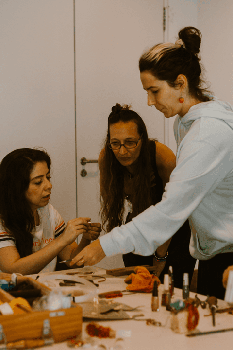 sesc paulista oficina de criação de jóais, alunas discutindo com a professora sobre peça criada por aluna'