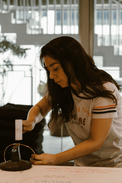 sesc paulista oficina de criação de jóais, aluna batendo com o martelo em parte de sua jóia, fazendo os retoques finais'