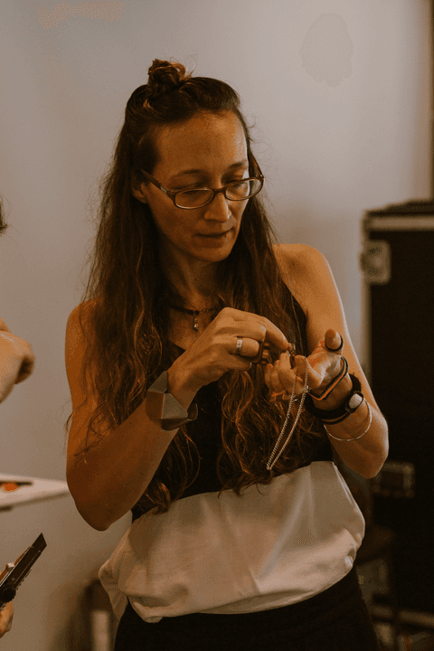 sesc paulista oficina de criação de jóais, professora com jóias na mão, conversando com aluna'