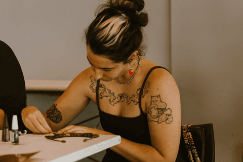 sesc paulista oficina de criação de jóais, aluna pintando sua peça com esmalte'