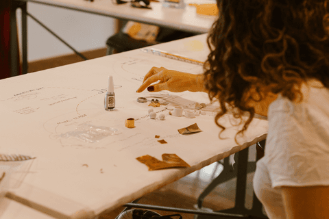 sesc paulista oficina de criação de jóais, outra aluna ainda trabalhando em suas peças, com muitos elementos sobre sua mesa'