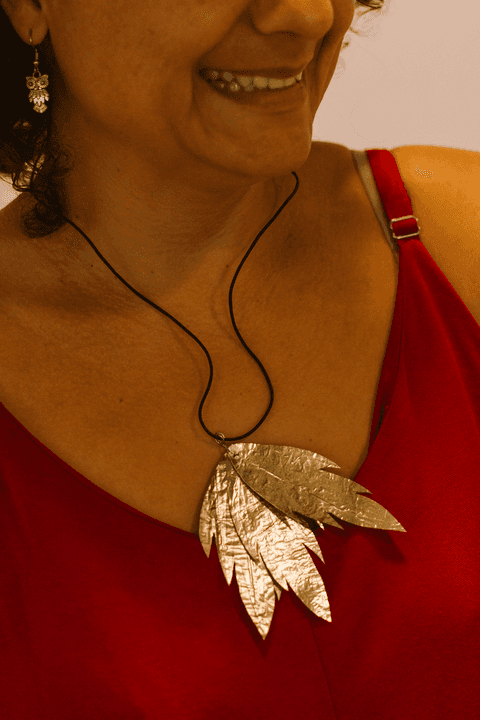 sesc paulista oficina de criação de jóais, colar de aluna em seu pescoço, flores douradas em cordão preto'