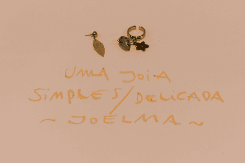 sesc paulista oficina de criação de jóais, brincos de outra aluna finalizados sobre a mesa, cartolina e frase que represente suas peças e suas intenções'