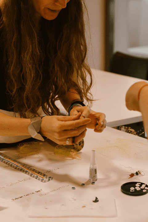 sesc paulista oficina de criação de jóais,mãos da professora carla manuseando objeto'