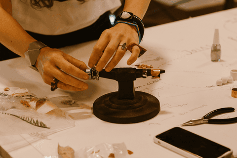 sesc paulista oficina de criação de jóais, professora apoiando anel em objeto para facilitar seu manuseio'