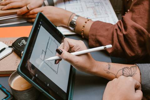 mãos de le e ni trabalhando em documentos e tablet'