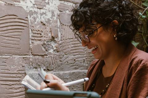 le sorrindo enquanto segura documentos de trabalho'