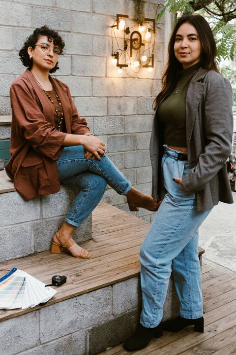le e ni na escadaria da cafeteria ao lado de fora, le sentada no degrau e ni em pé a sua frente'