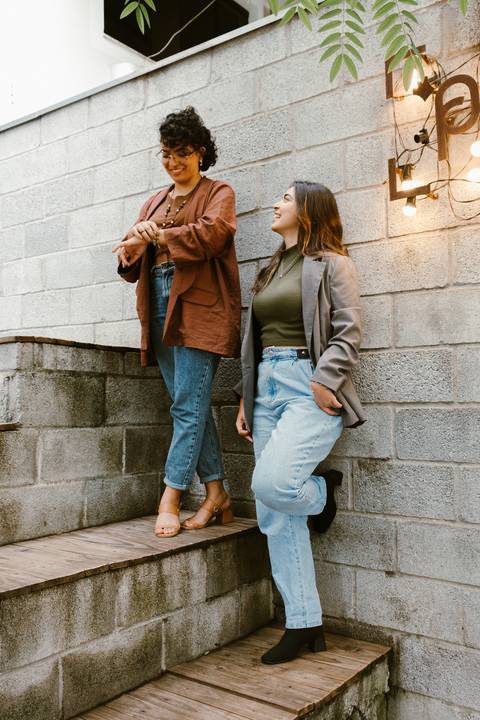 le e ni na escadaria da cafeteria ao lado de fora ambas em pé uma ao lado da outra'