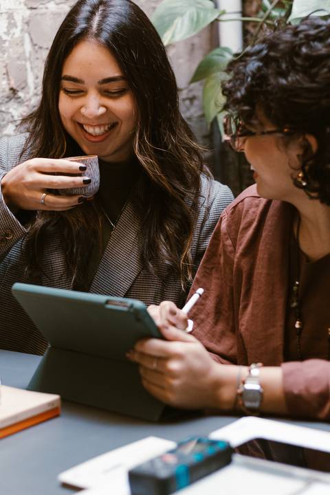 le e ni se olham e sorriem, enquanto trabalham em seus projetos'