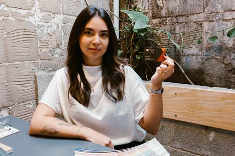 nicole com seu cartão de visita ao lado do seu rosto, sua marca'