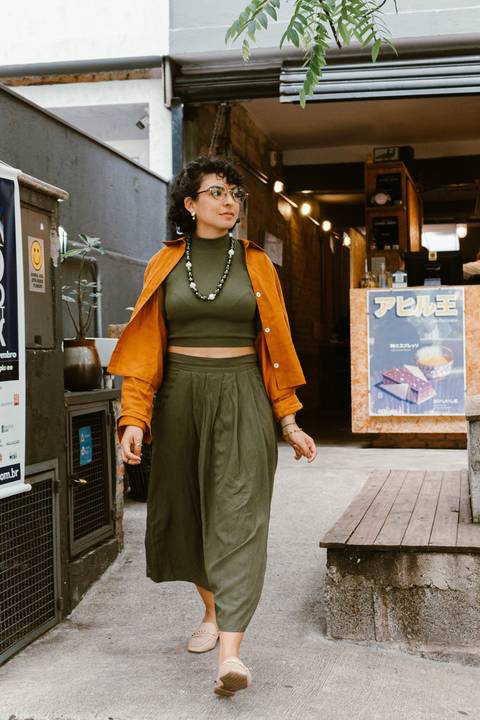 leticia na parte de fora da cafeteria em frente a escadaria, caminhando em direção a rua'