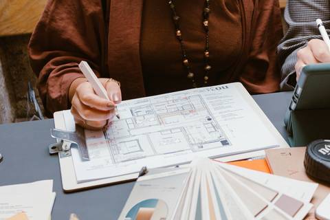 le escrevendo em seu projeto de arquitetura, sobre a mesa da cafeteria e os elementos ao redor'