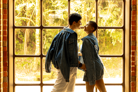 mika e le dentro da ferroviária, em frente as janelas de vidro, quase se beijando'