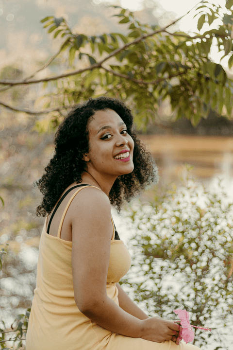 leticia sorrindo enquanto olha para mim, em frente ao lago'