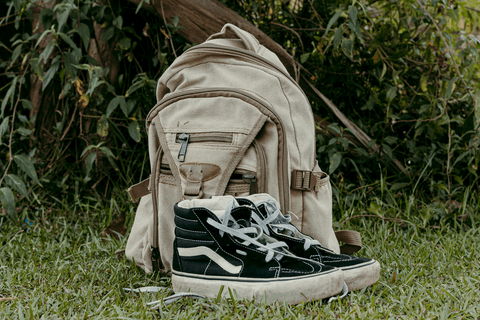mochila e sapatos da leticia em cima da grama no parque do carmo'
