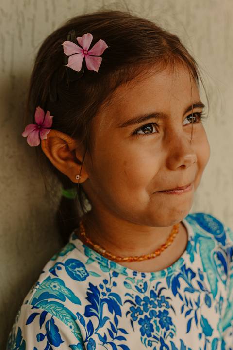 maria olhando para o lado, olhos bem brilhantes, segurando um sorriso'