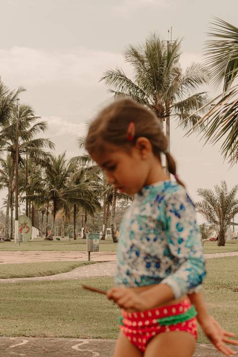 maria desfocada brincando no calçadão da praia'